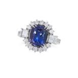 A TANZANITE AND DIAMOND DRESS RING set with an oval cushion cut tanzanite, in a cluster of round