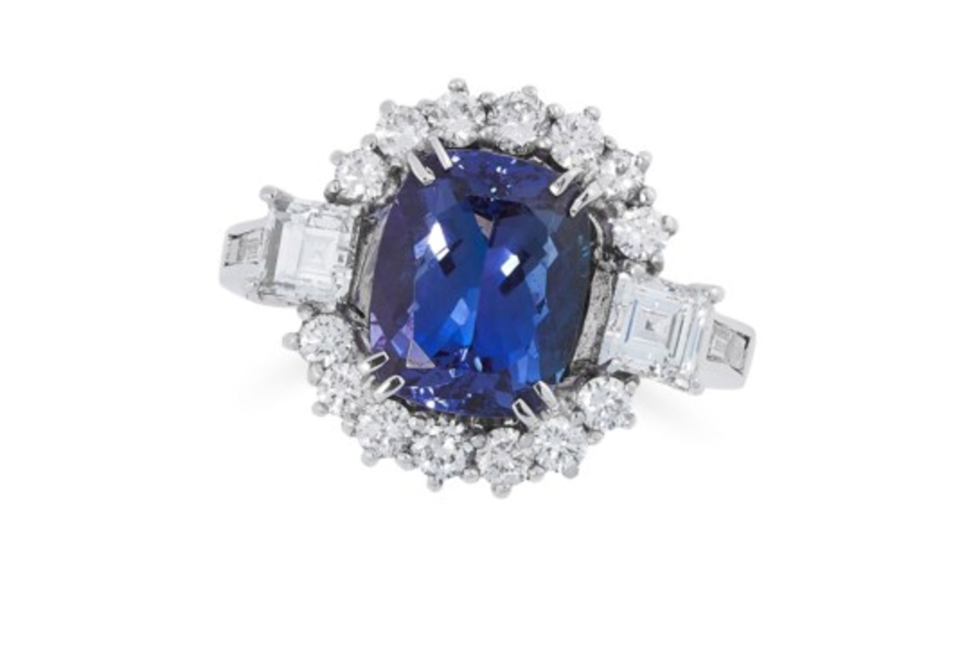 A TANZANITE AND DIAMOND DRESS RING set with an oval cushion cut tanzanite, in a cluster of round