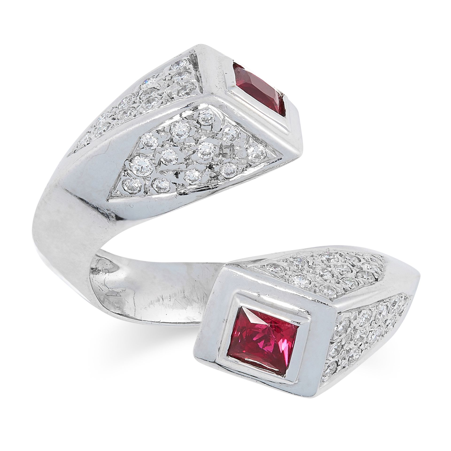 A RUBY AND DIAMOND CROSSOVER RING set with step cut rubies and pave set round brilliant cut