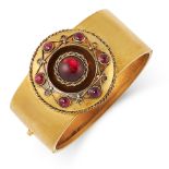 AN ANTIQUE GARNET BANGLE, 19TH CENTURY in yellow gold, the band with an applied circular motif