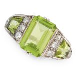 AN ART DECO PERIDOT AND DIAMOND RING set with an emerald cut peridot between two fancy cut