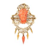 AN ANTIQUE CARVED CORAL DEMI PARURE, 19TH CENTURY in high carat yellow gold, comprising a brooch /