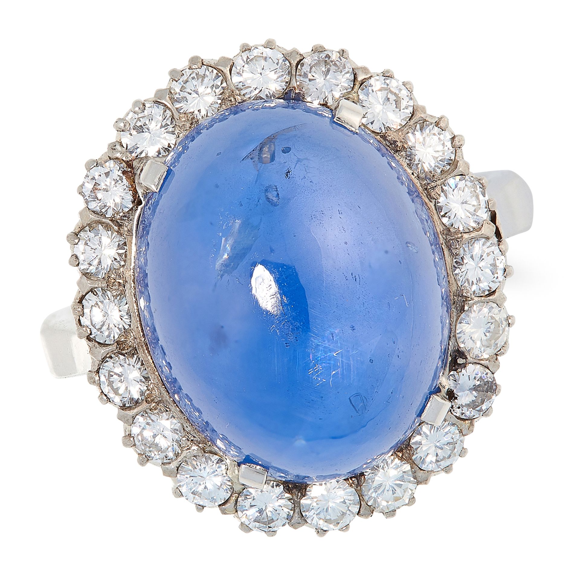 A CEYLON NO HEAT SAPPHIRE AND DIAMOND CLUSTER RING in platinum, set with a cabochon sapphire of 21.