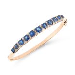 AN ANTIQUE SAPPHIRE AND DIAMOND BANGLE in high carat yellow gold, designed as a row of eleven