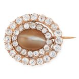 AN ANTIQUE CATS EYE CHRYSOBERYL AND DIAMOND BROOCH in high carat yellow gold, set with an oval