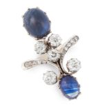 A SAPPHIRE AND DIAMOND DRESS RING in yellow gold, set with two oval cabochon sapphires within a