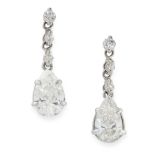 A PAIR OF DIAMOND DROP EARRINGS in platinum, each set with a pear cut diamond suspended below a trio