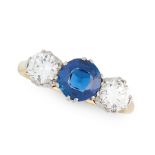 A SAPPHIRE AND DIAMOND THREE STONE RING in 18ct yellow gold, set with a round cut blue sapphire of