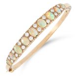 AN OPAL AND DIAMOND BANGLE in yellow gold, comprising a row of nine graduated oval cabochon opals