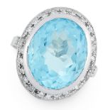 A TOPAZ AND DIAMOND RING in 18ct white gold, set with an oval cut topaz of 11.03 carats within a