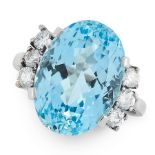 AN AQUAMARINE AND DIAMOND RING set with an oval cut aquamarine of 9.55 carats between trios of round