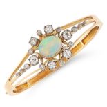 AN ANTIQUE OPAL AND DIAMOND BANGLE in high carat yellow gold, set with a cabochon opal in a border