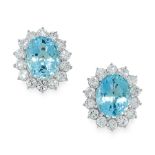 A PAIR OF AQUAMARINE AND DIAMOND STUD EARRINGS each set with an oval cut aquamarine within a