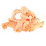 A CORAL BROOCH comprising of a single piece of carved coral, depicting a cherub on a fish, unmarked,