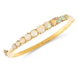 AN OPAL AND DIAMOND BANGLE in yellow gold, the hoop half set with a row of eleven graduated oval