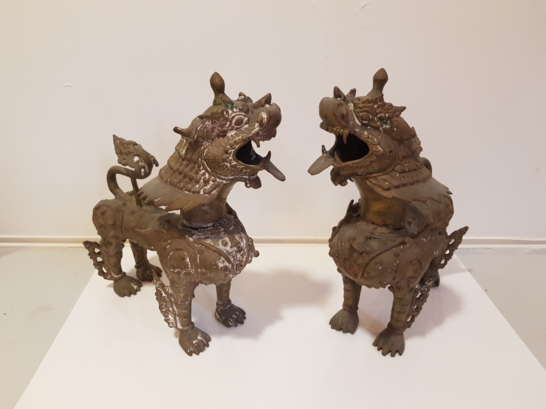 A pair of east Asian style cast base metal standing lions