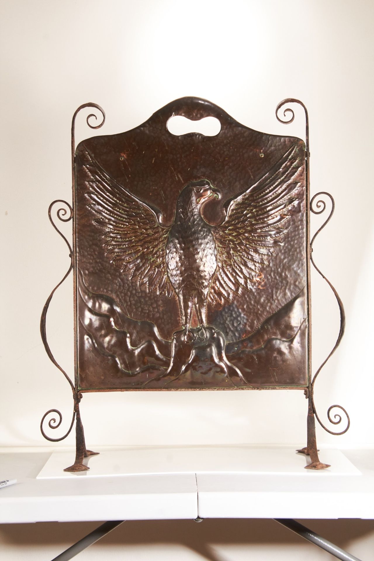 An early 20th century arts and crafts wrought iron and beaten copper fire screen, probably American