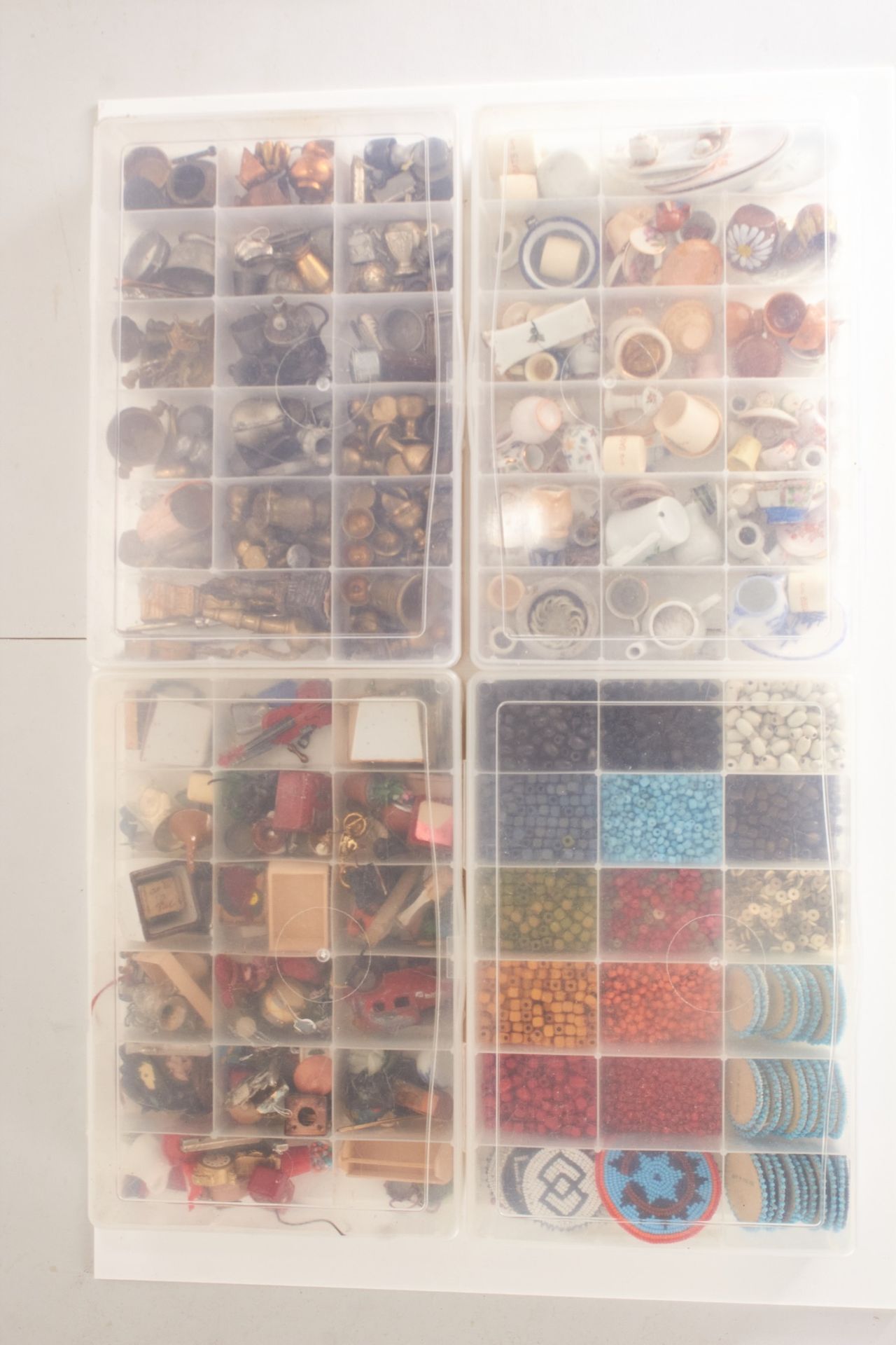 Four boxes of dolls house ornaments and crafting materials