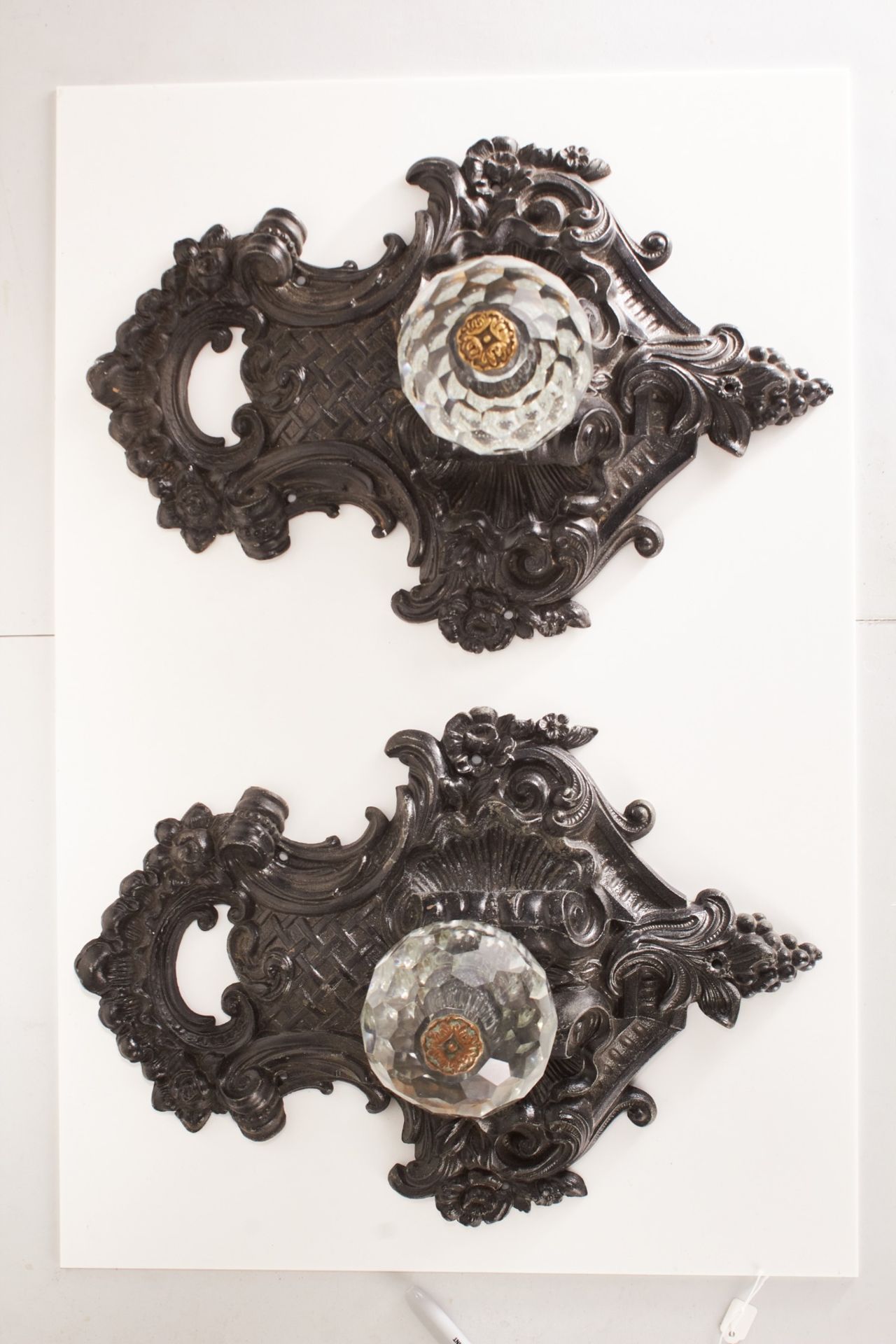 A pair of early 20th century die-cast lead alloy door pull surrounds, circa 1910