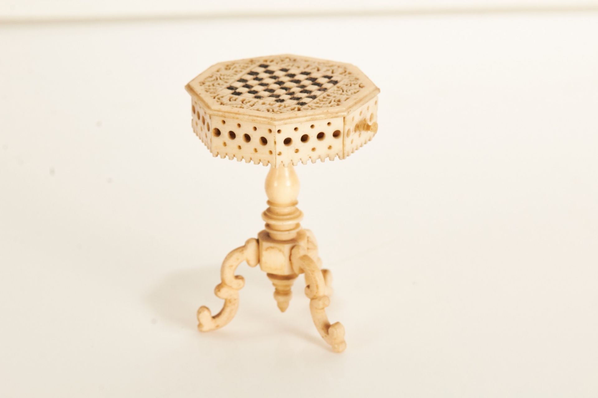 A 19th century carved and stained ivory prisoner of war work miniature chess table