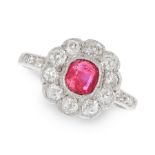 A RUBY AND DIAMOND CLUSTER RING in white gold or platinum, set with a cushion cut ruby of 0.55