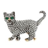A DIAMOND AND EMERALD CAT BROOCH in yellow gold and silver, designed as a prowling cat, jewelled all