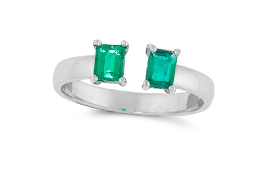 A COLOMBIAN EMERALD DRESS RING in 18ct white gold, the open band set with two emerald cut emeralds