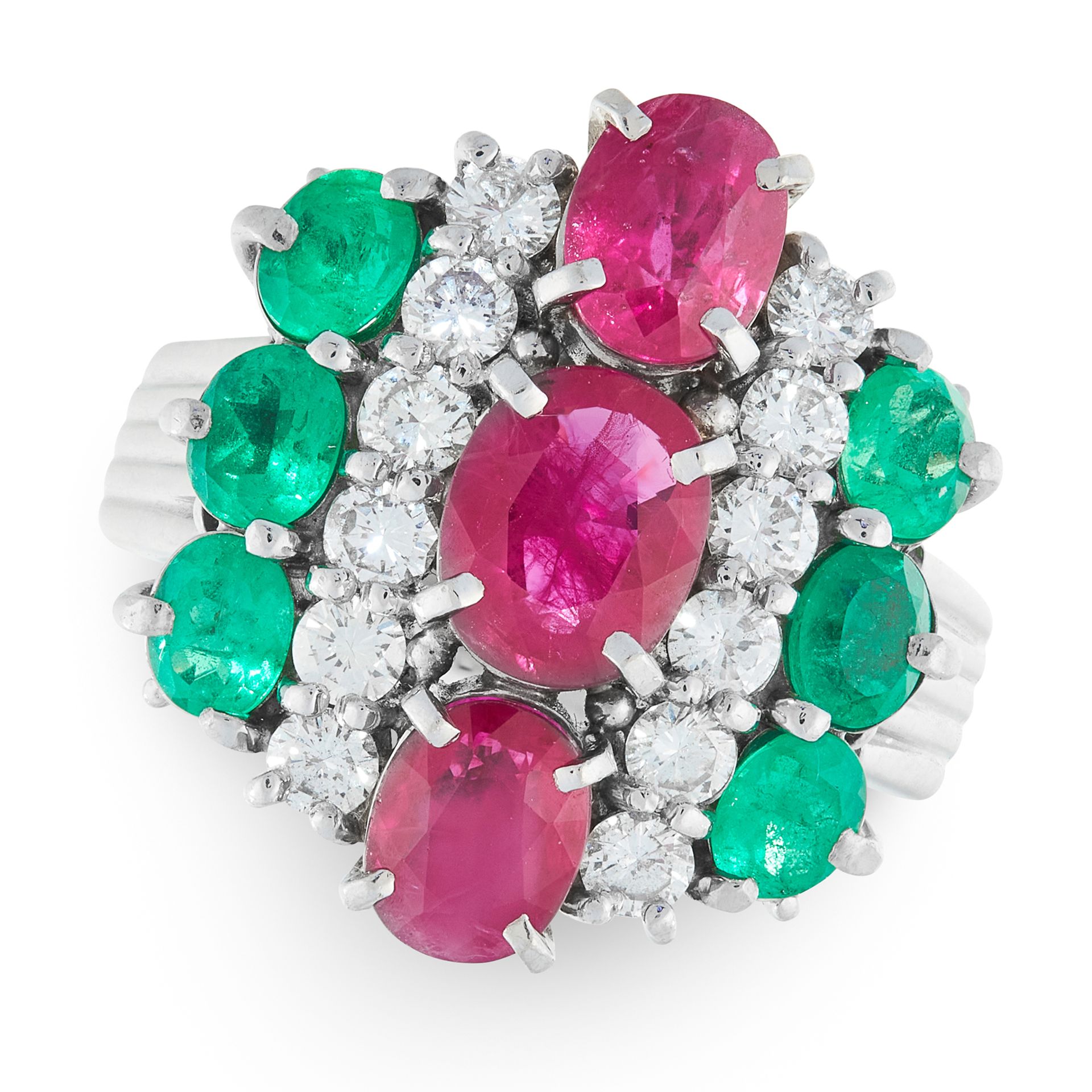 A RUBY, EMERALD AND DIAMOND DRESS RING in platinum, set with a trio of graduated oval cut rubies