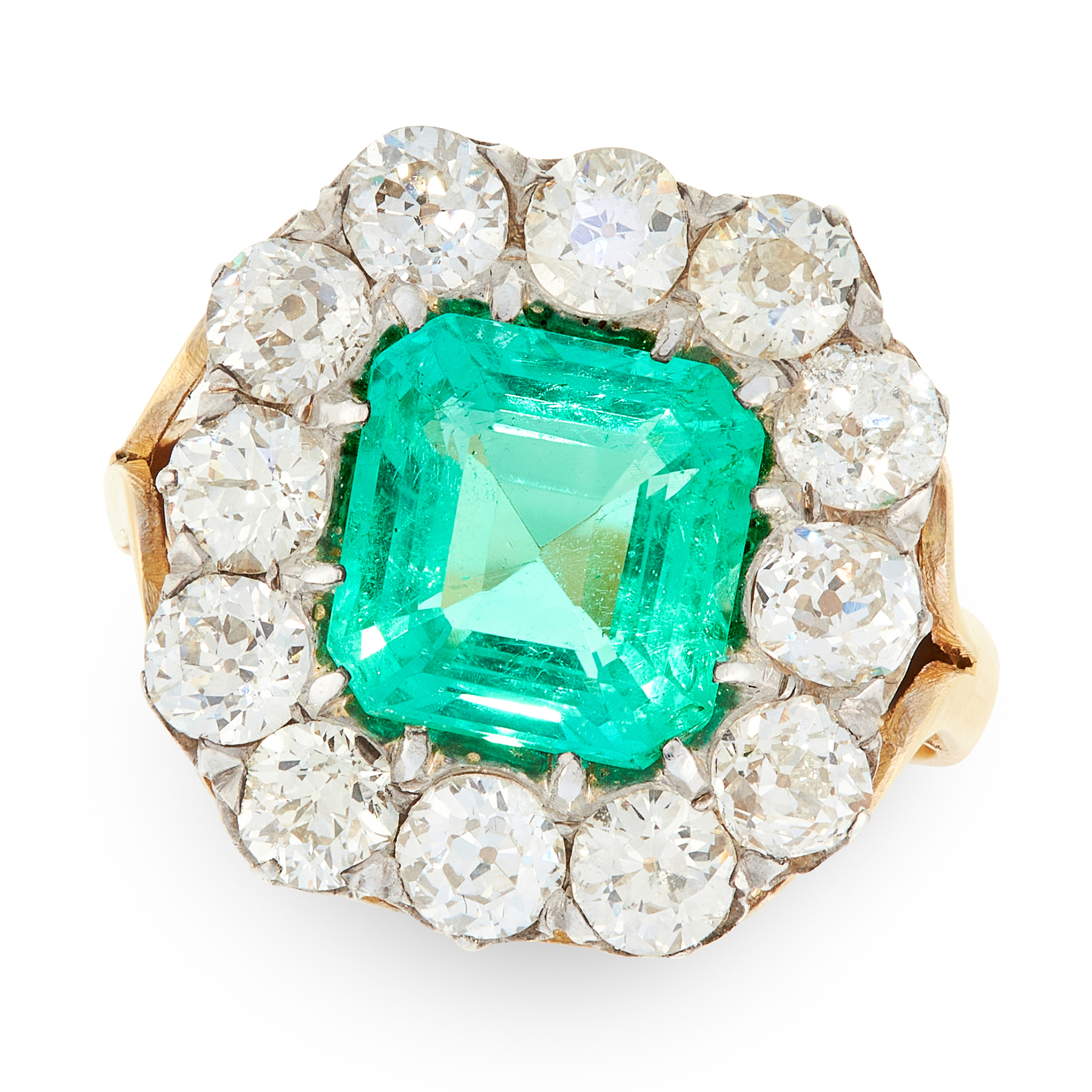 A COLOMBIAN EMERALD AND DIAMOND CLUSTER RING in 18ct yellow gold and silver, set with an emerald cut