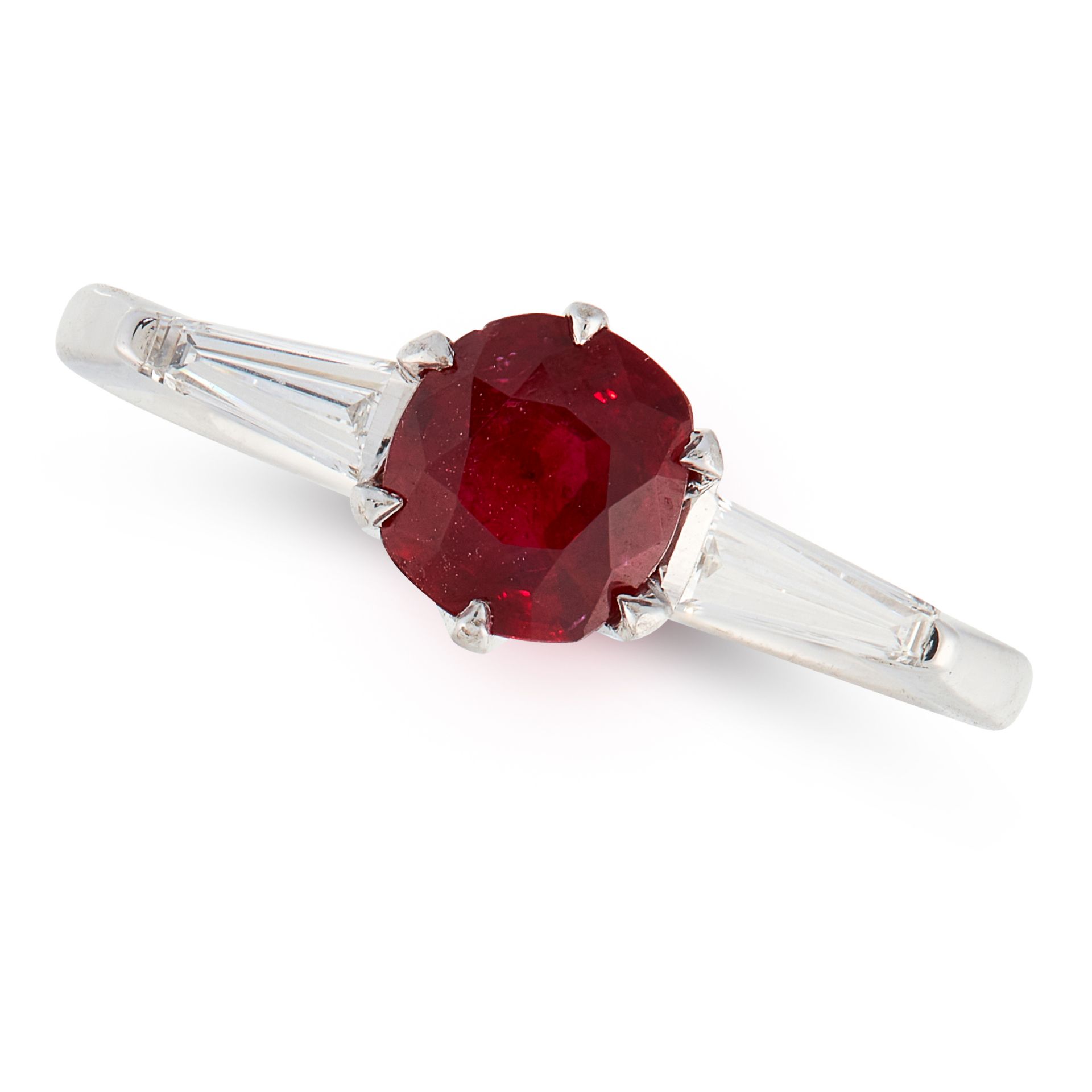 A RUBY AND DIAMOND RING set with a cushion cut ruby of 1.16 carats between two tapered baguette