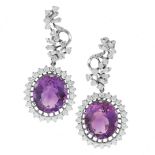 A PAIR OF AMETHYST AND DIAMOND EARRINGS in 18ct white gold, each set with an oval cut amethyst of