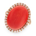 A CORAL AND DIAMOND RING in yellow gold, set with a large cabochon coral in a border of round cut
