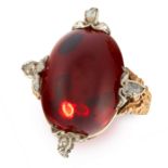 AN ANTIQUE GARENT AND DIAMOND DRESS RING in yellow gold, set with an oval cabochon garnet accented