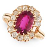 A RUBY AND DIAMOND CLUSTER RING in yellow gold, set with an oval cut ruby of 2.07 carats in a border