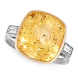 A YELLOW SAPPHIRE AND DIAMOND RING set with a cushion cut yellow sapphire of 13.09 carats between