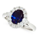 A SYNTHETIC SAPPHIRE AND DIAMOND CLUSTER RING in platinum, set with an oval cut sapphire in a border