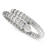 A DIAMOND AND EMERALD SNAKE BANGLE designed as a coiling snake, the articulated body jewelled