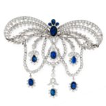A SAPPHIRE AND DIAMOND BOW BROOCH designed as a large bow accented by foliate sprays and swags,