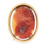 AN ANTIQUE CARVED HARDSTONE BROOCH in yellow gold, set with an oval piece of carnelian, carved in