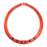 A CORAL AND JET BEAD NECKALCE in 18ct yellow gold, comprising three rows of graduated polished coral