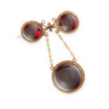AN ANTIQUE GARNET BROOCH, 19TH CENTURY in 15ct yellow gold, the body set with two round cabochon
