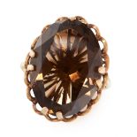 A SMOKY QUARTZ DRESS RING in yellow gold, set with an oval cut smoky quartz within a scalloped