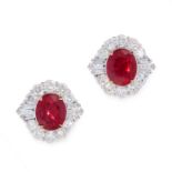 A PAIR OF RUBY AND DIAMOND EARRINGS in 18ct white gold, each set with an oval cut ruby within a
