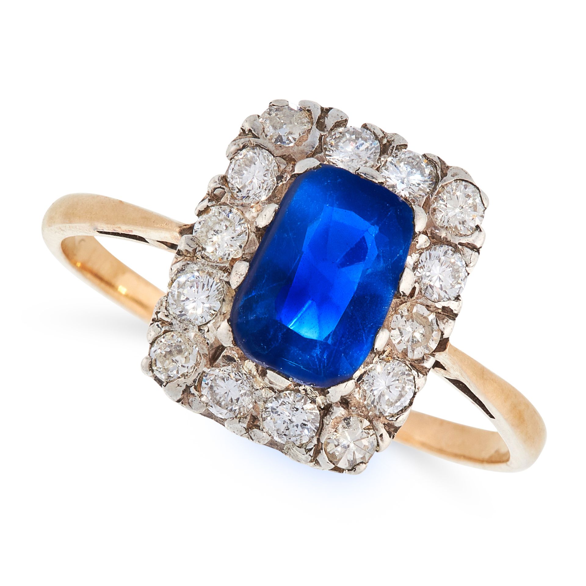 A SAPPHIRE AND DIAMOND DRESS RING in high carat yellow gold, set with a cushion cut blue sapphire of