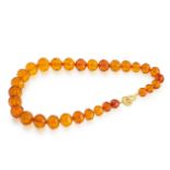 AN AMBER BEAD NECKLACE set with a graduated row of thirty faceted amber beads, unmarked, 54cm, 92.