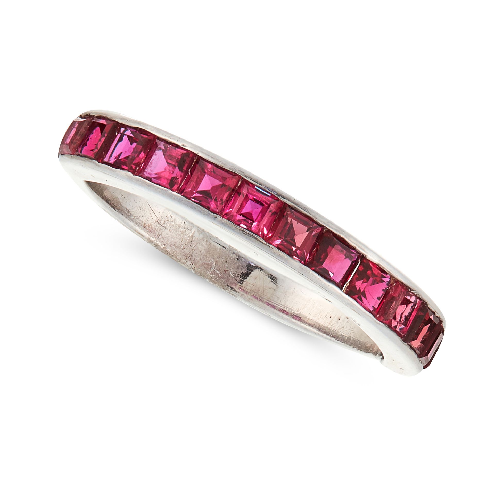 A RUBY HALF ETERNITY RING in 18ct white gold, set with a row of step cut rubies, stamped 18CT,