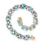 A GEMSET LINE BRACELET in yellow gold, comprising a single row of fourteen cushion cut blue