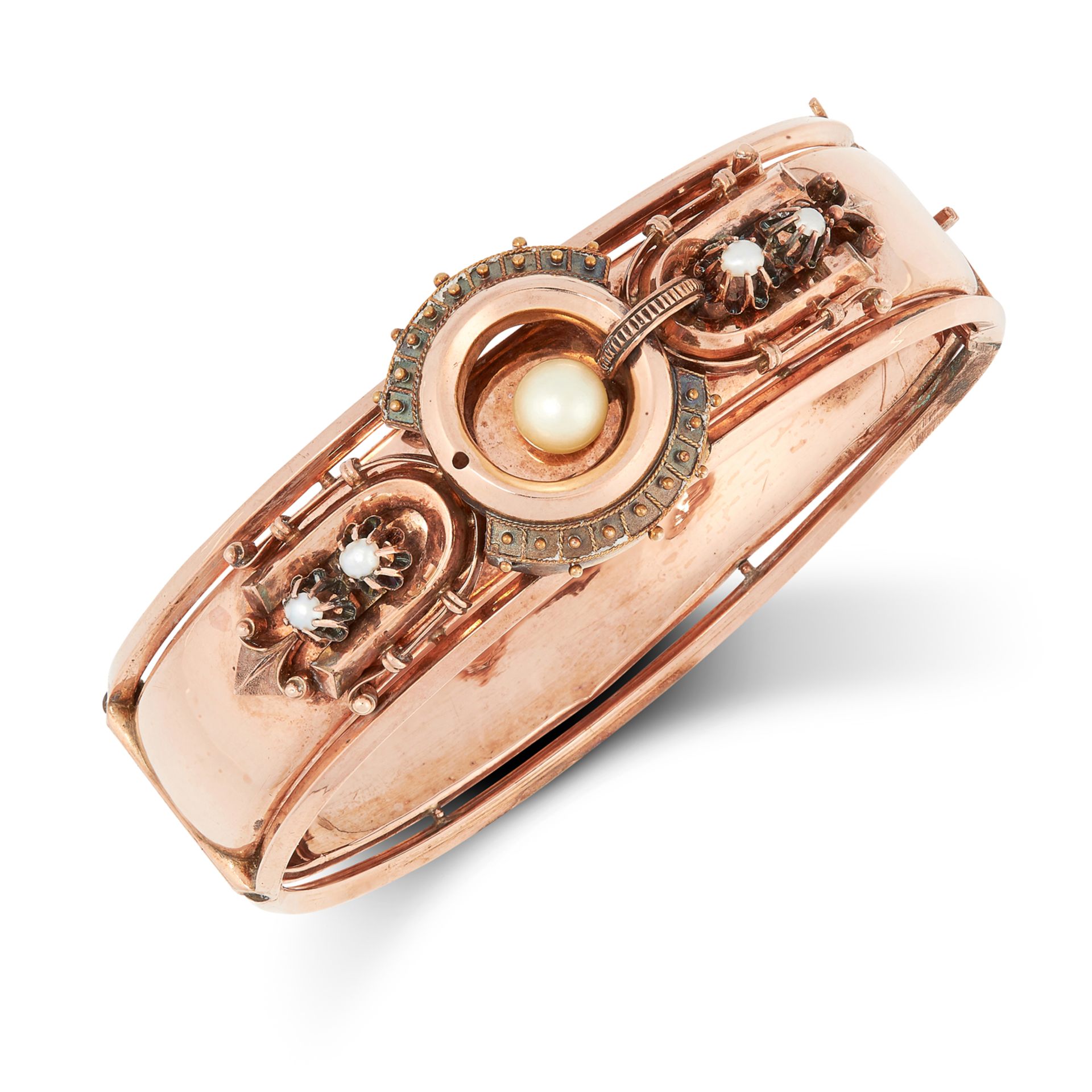 AN ANTIQUE PEARL BANGLE in yellow gold, the stylised band with decorative motifs set with pearls,