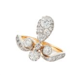 AN ANTIQUE DIAMOND DRESS RING in high carat yellow gold, the stylised scrolling band accented by a