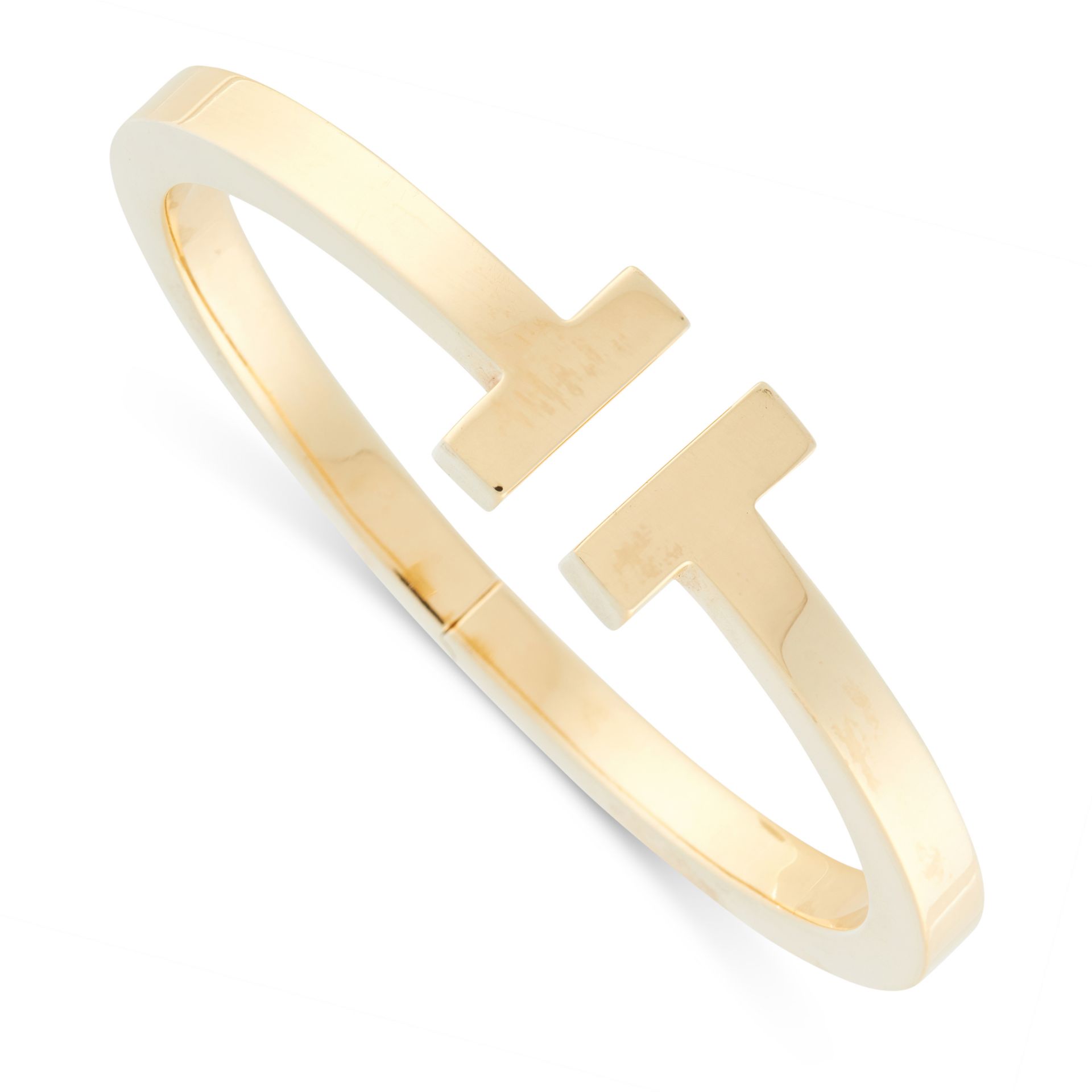 A T SQUARE BRACELET / BANGLE, TIFFANY & CO in 18ct yellow gold, the incomplete band terminated at